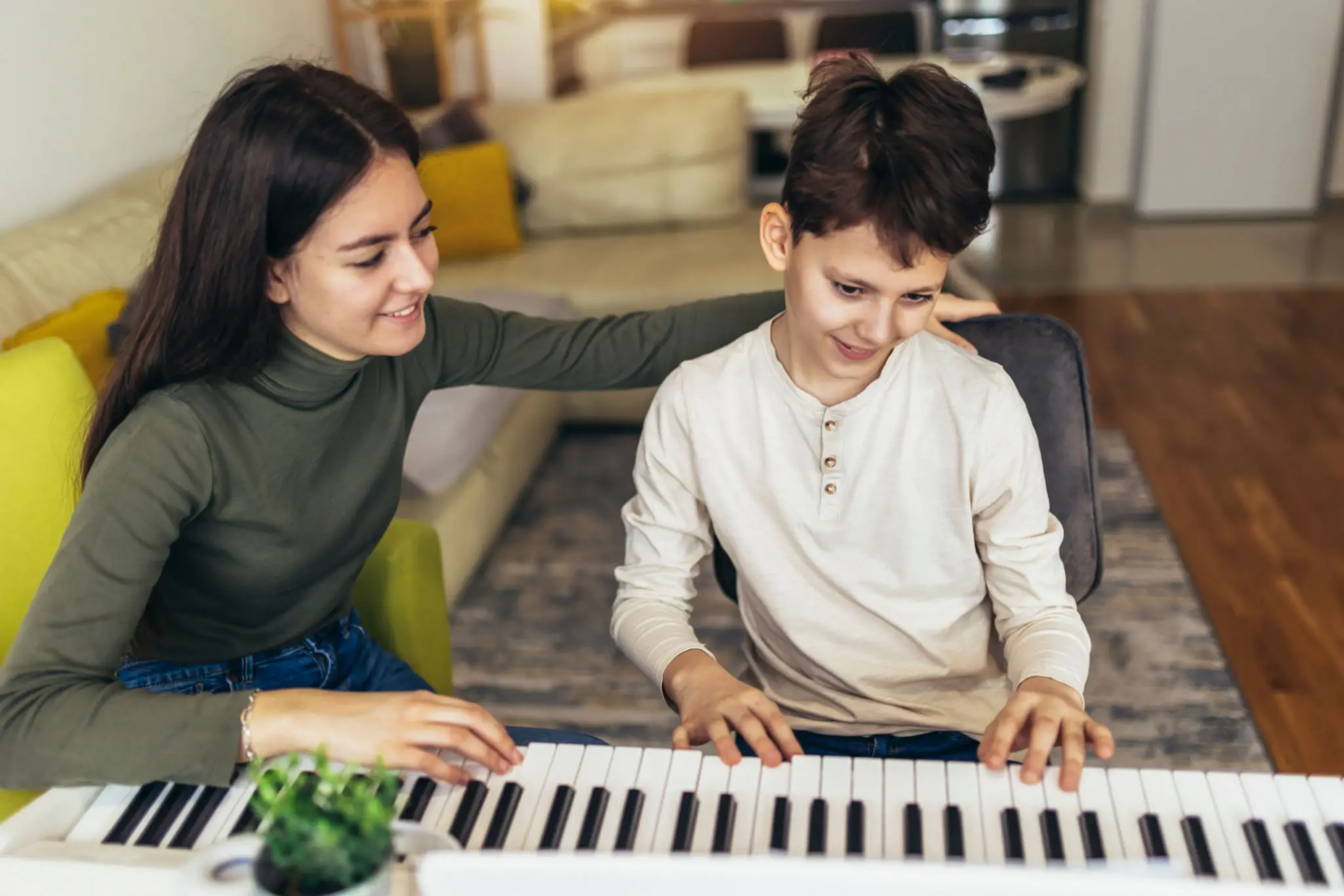 Parent and child playing keyboard together at home