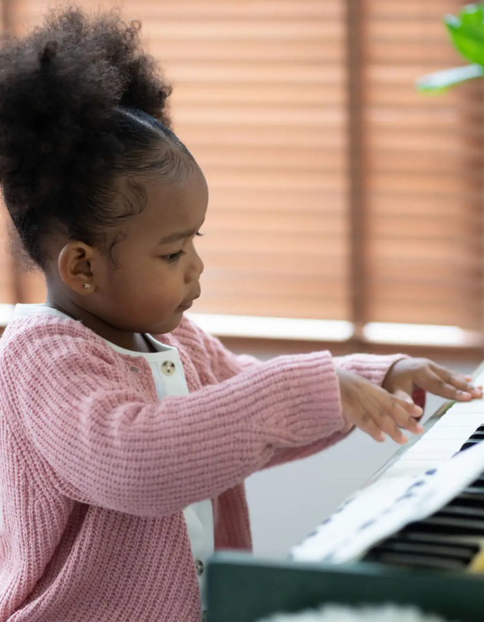Child at the piano during a lesson